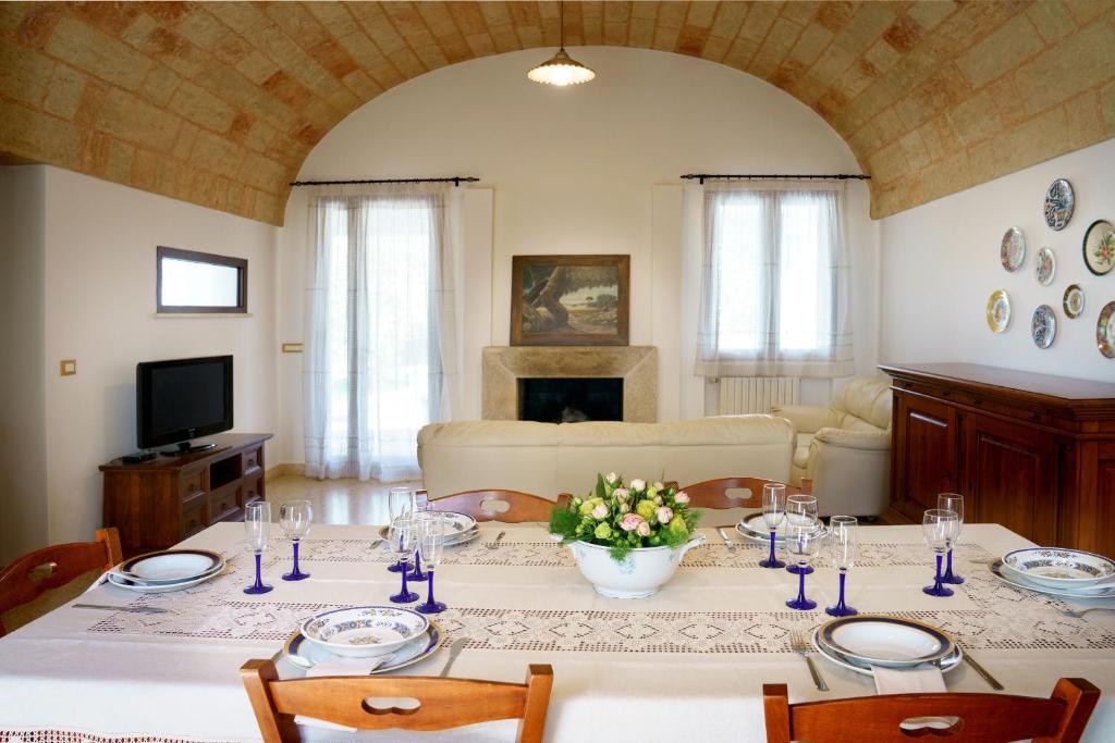 une salle à manger avec une table et un salon dans l'établissement Villa Nichil, à Tricase