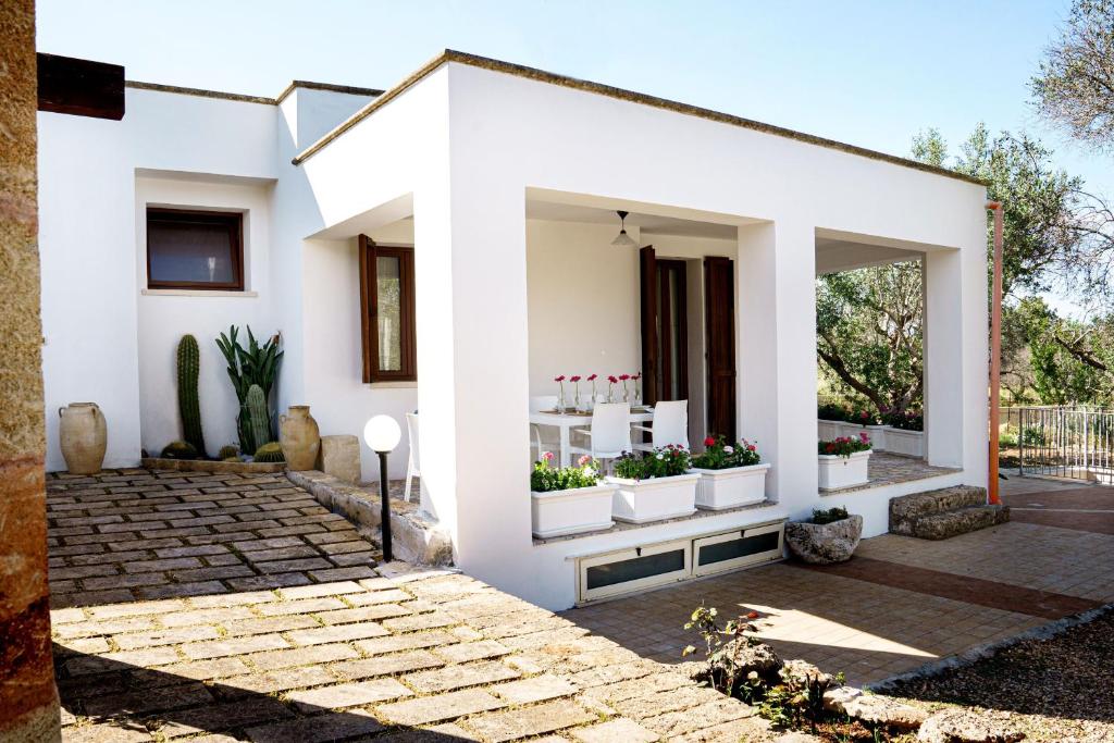 une maison blanche avec des plantes à la fenêtre dans l'établissement Villa Nichil, à Tricase