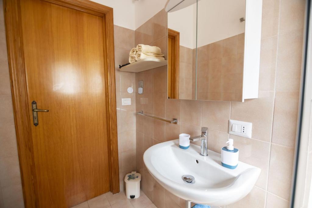 une salle de bain avec un lavabo et un miroir dans l'établissement filìa ϕιλία, à Serranova