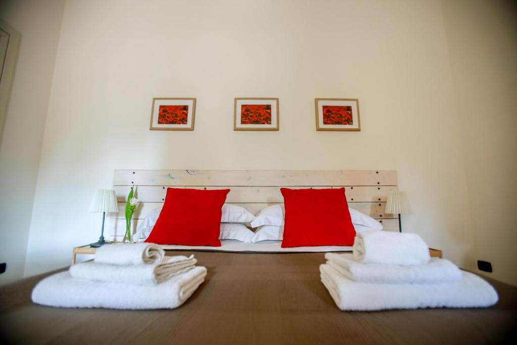 une chambre avec un lit avec des oreillers rouges et blancs dans l'établissement Villa indipendente con piscina privata by Pugliadamare, à San Michele Salentino