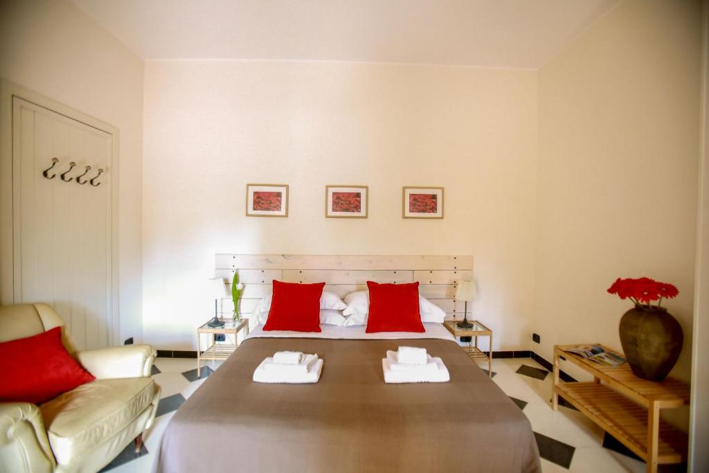 une chambre avec un grand lit avec des oreillers rouges dans l'établissement Villa indipendente con piscina privata by Pugliadamare, à San Michele Salentino 63 autres photos