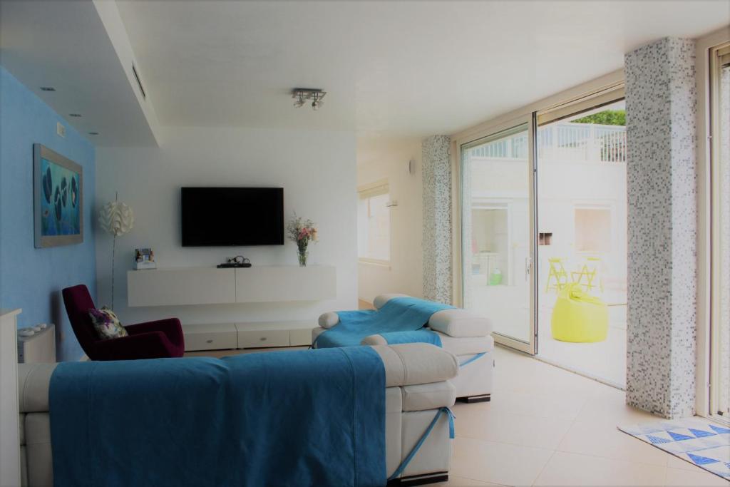 un salon avec un canapé et une télévision dans l'établissement Villa Caraitria, à Martina Franca