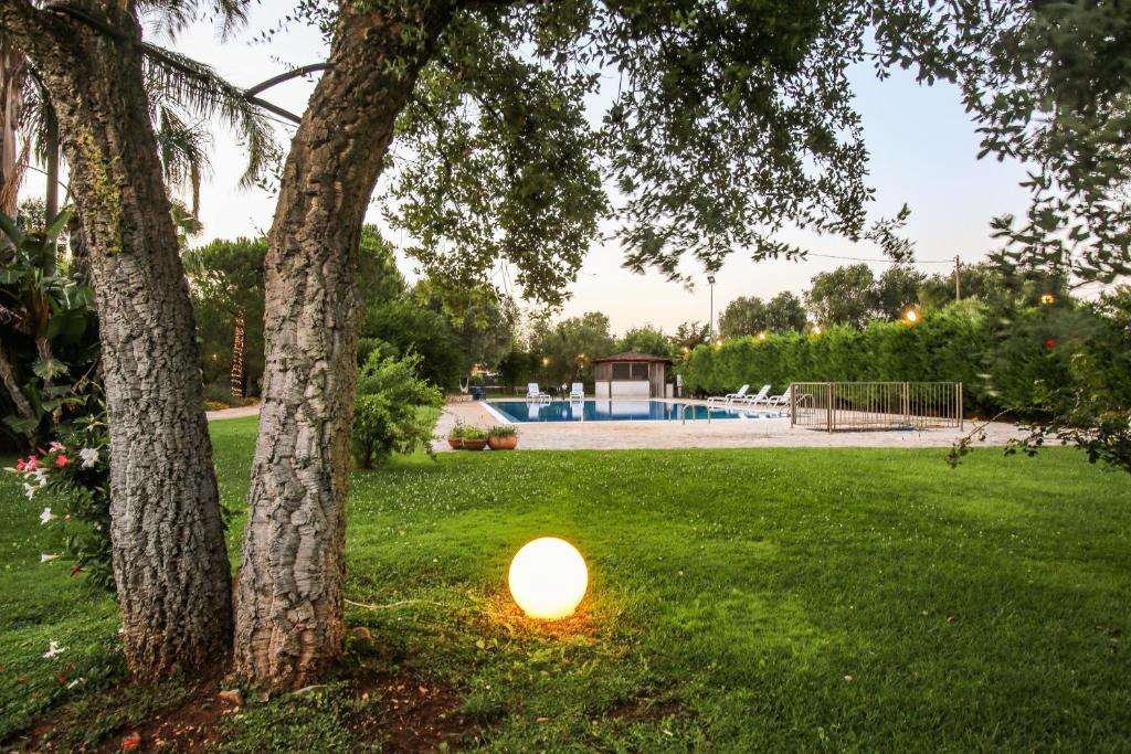 une lumière dans l'herbe à côté d'un arbre dans l'établissement Villa con parco e piscina, à San Michele Salentino