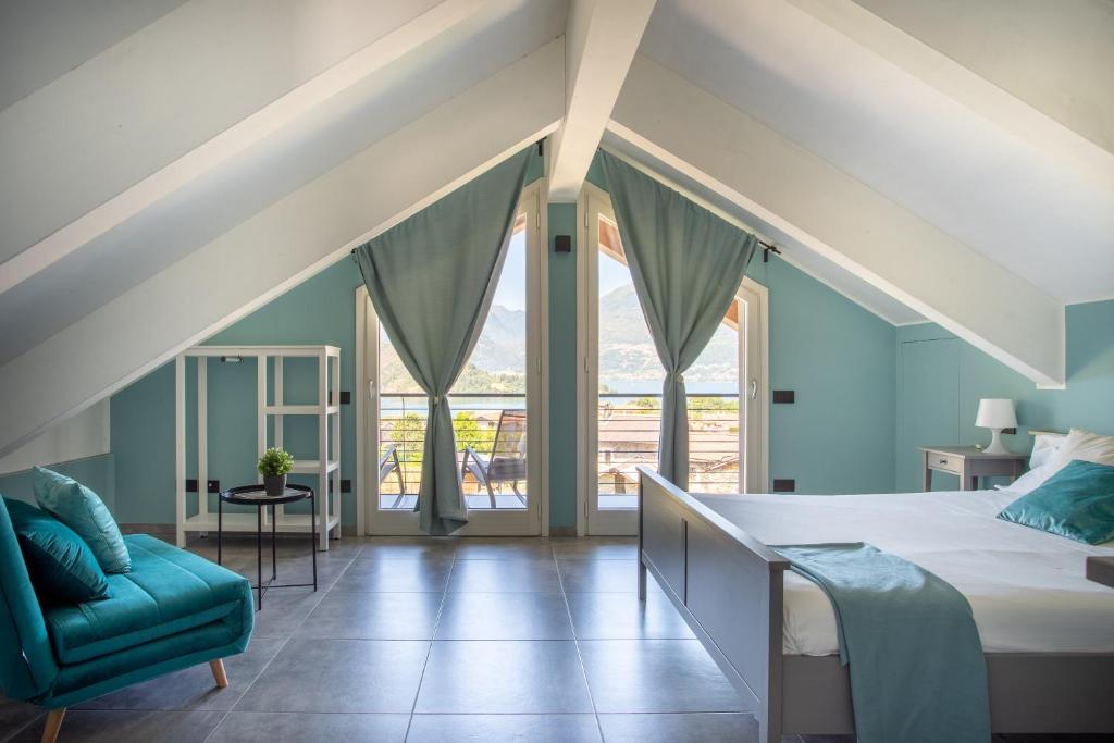 - une chambre avec des murs bleus, un lit et une chaise dans l'établissement Villa Vento, à Colico