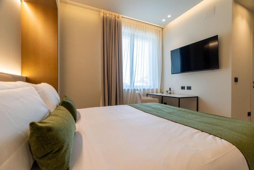 une chambre d'hôtel avec un lit et une télévision à écran plat dans l'établissement Villa Verdeoro, à Montesilvano