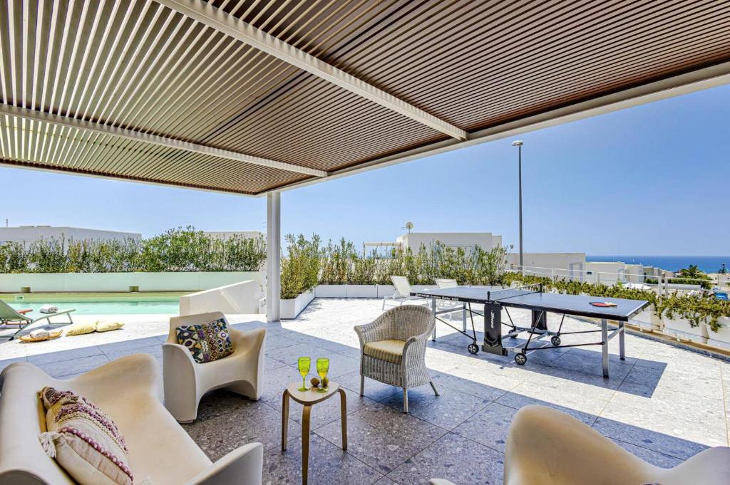 un patio extérieur avec une table et des chaises dans l'établissement Villa Brezza Marina by Villa Plus, à Marina di Ragusa