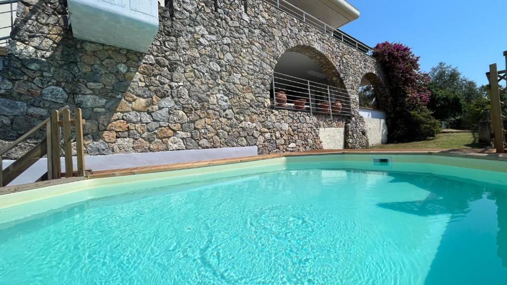 une piscine devant un bâtiment en pierre dans l'établissement Villa Bianca Luxury & Prestige, à Massarosa