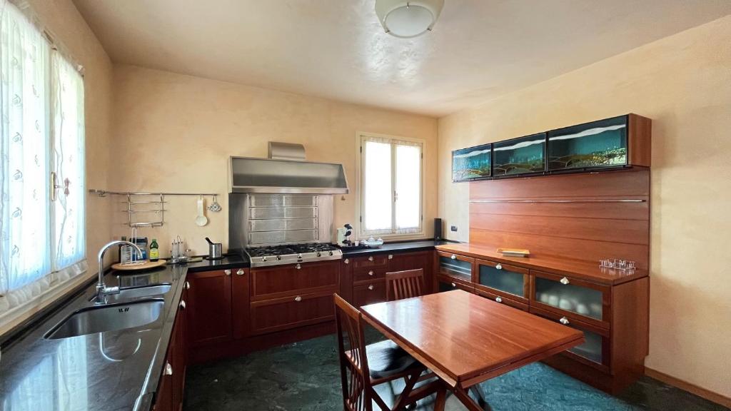 une cuisine avec des armoires en bois et une table en bois dans l'établissement Villa Bianca Luxury & Prestige, à Massarosa 33 autres photos