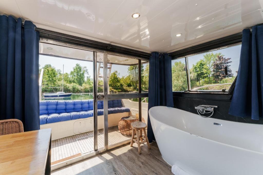 Cette chambre dispose d'une grande fenêtre et d'une baignoire. dans l'établissement L'Escale Royale Saint-Martin-la-Garenne Port Ilon - Seine - Giverny, à Saint-Martin-la-Garenne