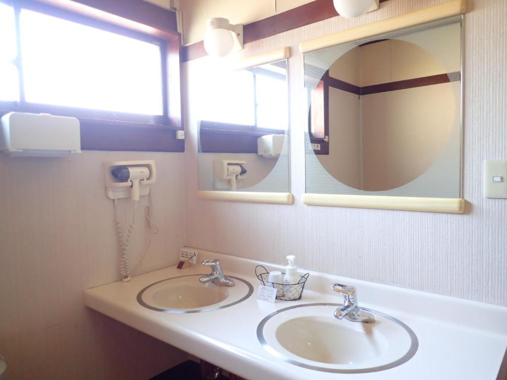 une salle de bain avec deux lavabos et un miroir dans l'établissement Oyado Matsubaya, à Minakami