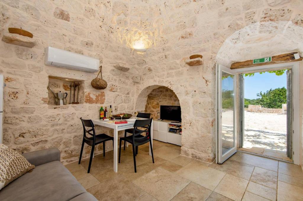 une cuisine et une salle à manger avec une table et des chaises dans l'établissement Villa Trullo Ettore by Villa Plus, à Ceglie Messapica