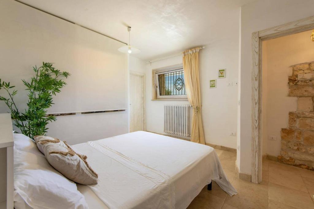 une chambre avec un lit blanc et une fenêtre dans l'établissement Villa Angelo by Villa Plus, à Ostuni 40 autres photos