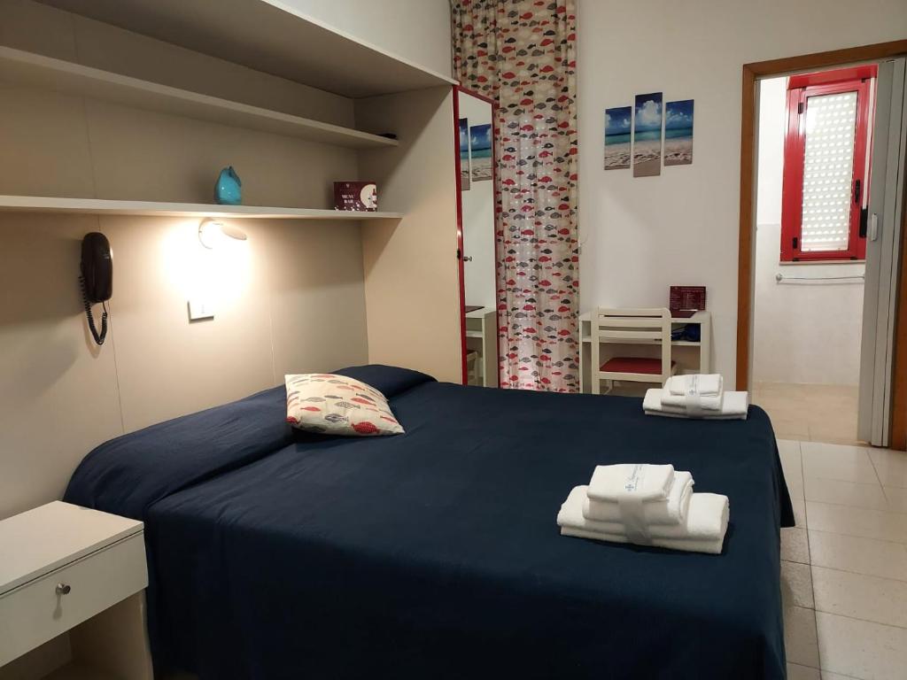 une chambre avec un lit bleu avec des serviettes dessus dans l'établissement Hotel Villa Susy, à Davoli