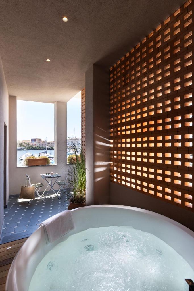 une grande baignoire dans une pièce avec une grande fenêtre dans l'établissement Casa Miranda Boutique, à Syracuse