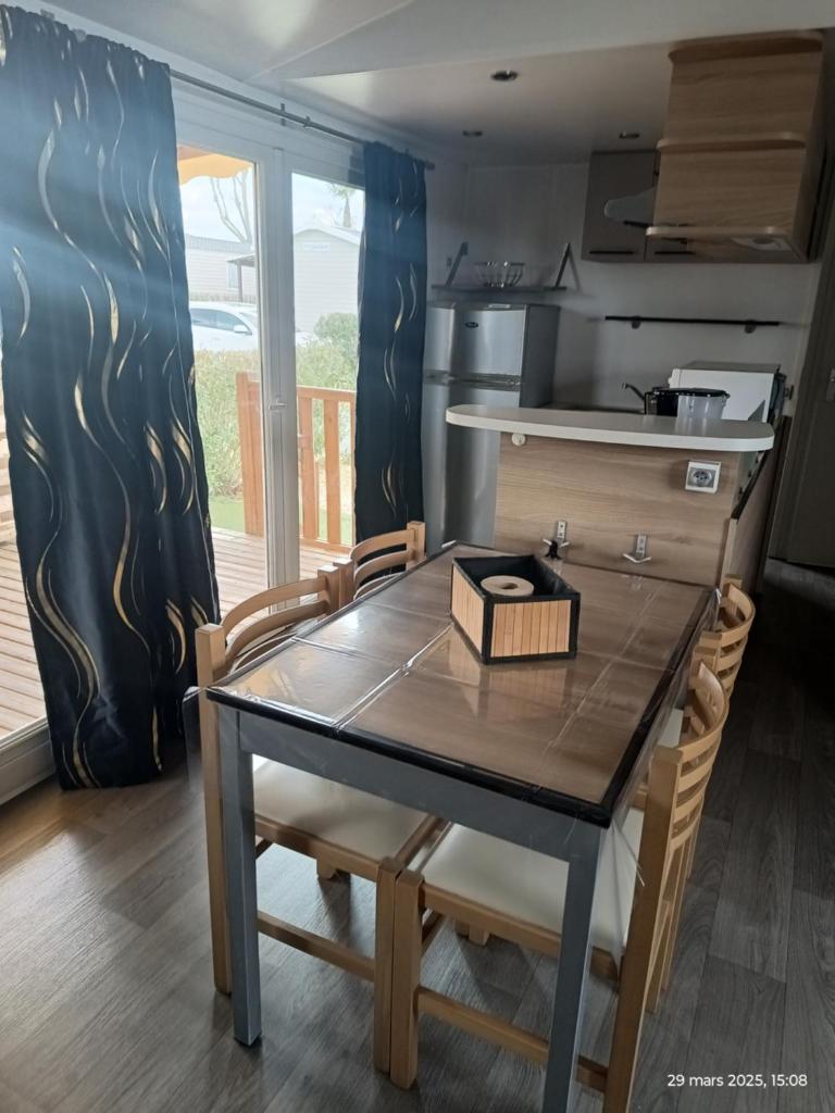 une cuisine avec une table et des chaises dans une cuisine dans l'établissement Camping les sables du midi à Valras plage, à Valras-Plage 7 autres photos