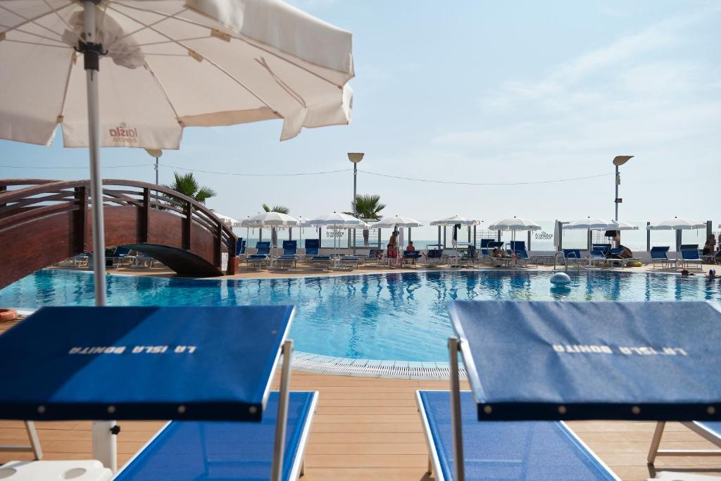 une piscine avec des chaises et un parasol dans l'établissement La Isla Resort, à Pontecagnano