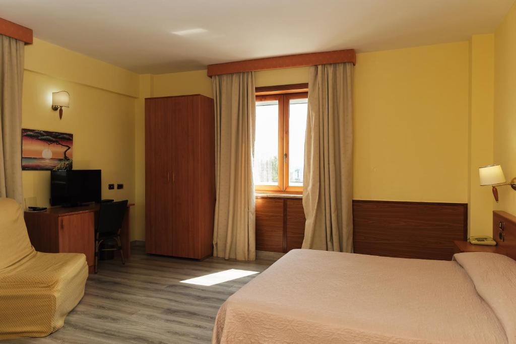 une chambre d'hôtel avec un lit et une fenêtre dans l'établissement La Isla Resort, à Pontecagnano