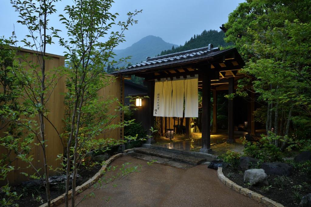 un bâtiment avec un pavillon dans un jardin dans l'établissement Shima Onsen Yoshimoto, à Nakanojo
