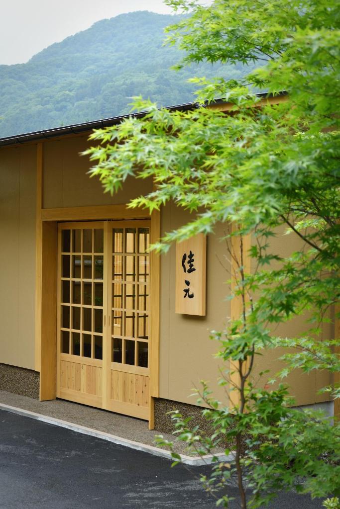 un bâtiment avec une enseigne sur le côté dans l'établissement Shima Onsen Yoshimoto, à Nakanojo