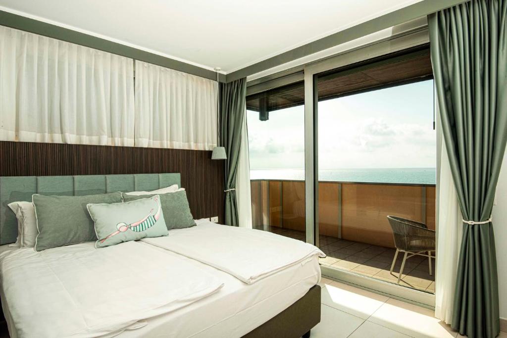 une chambre avec un lit et un balcon avec l'océan dans l'établissement Hotel Europa Lignano, à Lignano Sabbiadoro 257 autres photos