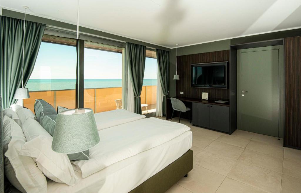 une chambre avec un lit, un bureau et une télévision dans l'établissement Hotel Europa Lignano, à Lignano Sabbiadoro