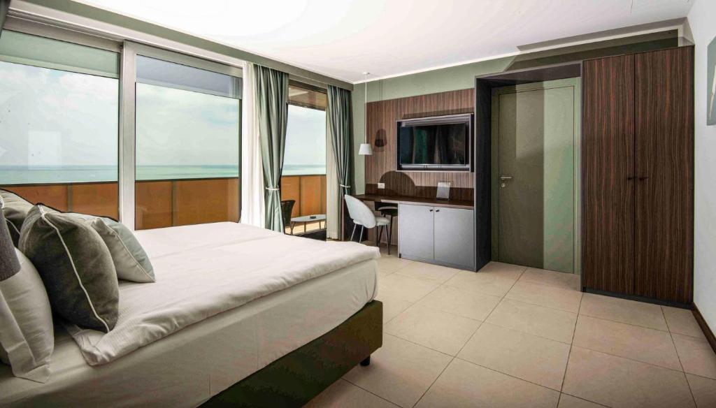 une chambre avec un lit et un bureau dans une pièce dans l'établissement Hotel Europa Lignano, à Lignano Sabbiadoro
