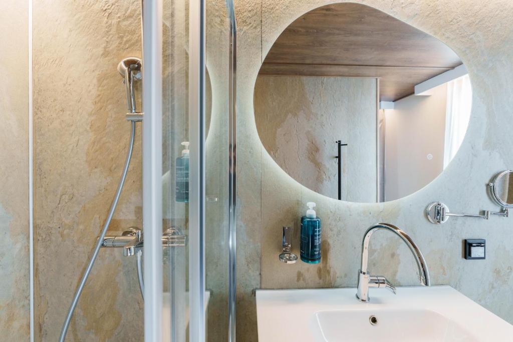 une salle de bain avec un lavabo et une douche avec un miroir dans l'établissement L'Escale Royale Saint-Martin-la-Garenne Port Ilon - Seine - Giverny, à Saint-Martin-la-Garenne 37 autres photos
