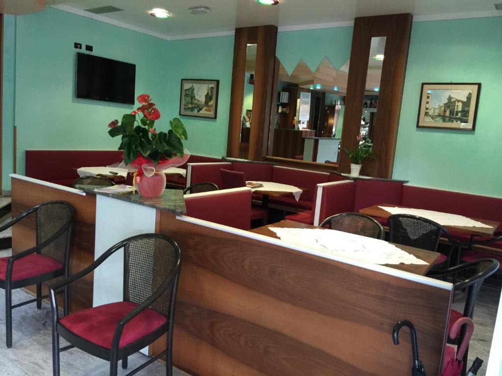 un restaurant avec des tables et des chaises et un bar dans l'établissement Hotel Ragno D'Oro, à Sottomarina