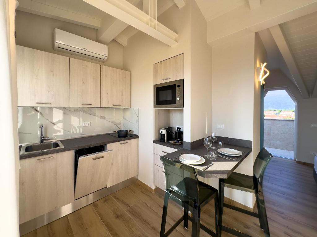 - une cuisine avec une petite table et un comptoir dans l'établissement Junior Suite Hotel Biagi, à Lido di Camaiore