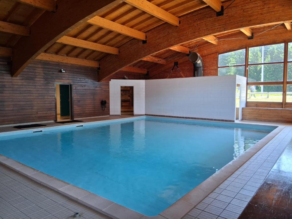 une piscine intérieure avec un grand bassin bleu dans l'établissement Résidence l'Ecrin des Neiges, à Chamrousse