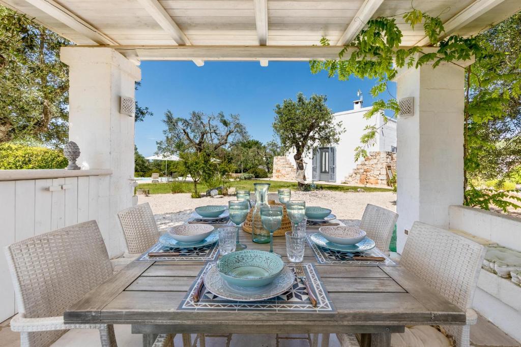- une table en bois sur une terrasse avec des chaises dans l'établissement Trullo Sant`Andrea by Perle di Puglia, à Ceglie Messapica