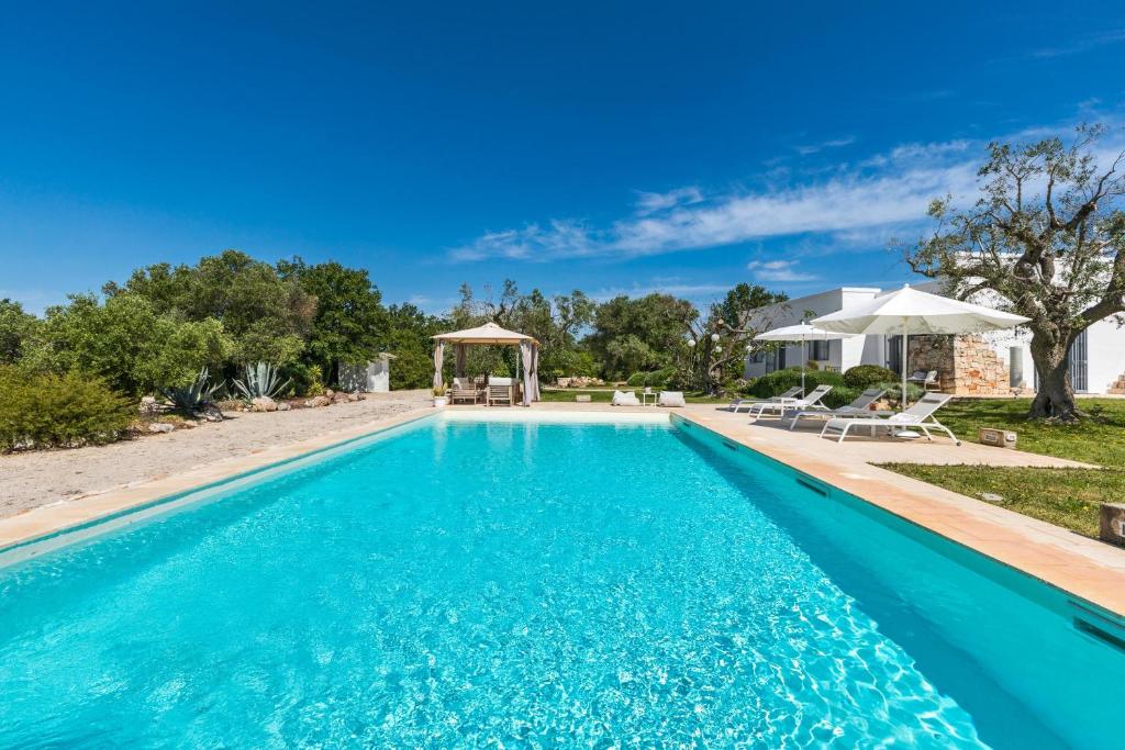 une piscine avec un kiosque et une maison dans l'établissement Trullo Sant`Andrea by Perle di Puglia, à Ceglie Messapica