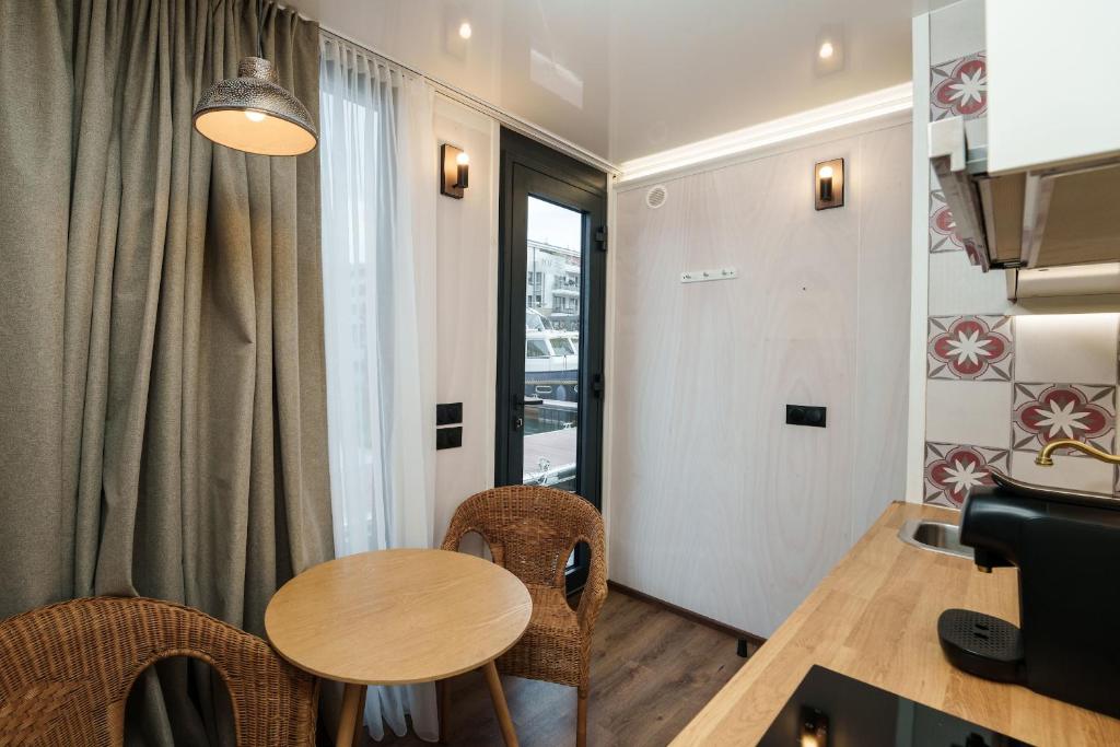 une salle à manger avec une table et des chaises et une fenêtre dans l'établissement L'Escale Royale L'Isle Adam Port - Oise, à LʼIsle-Adam 25 autres photos