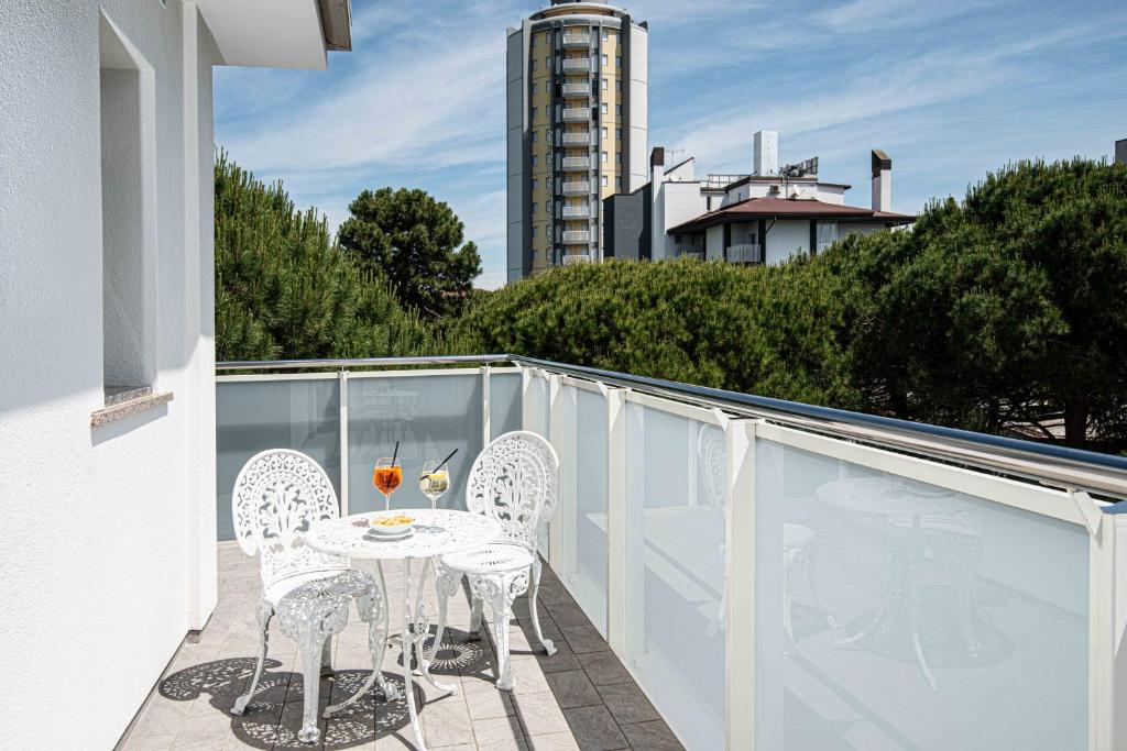 un patio avec une table et des chaises sur un balcon dans l'établissement Hotel Oasi, à Lignano Sabbiadoro