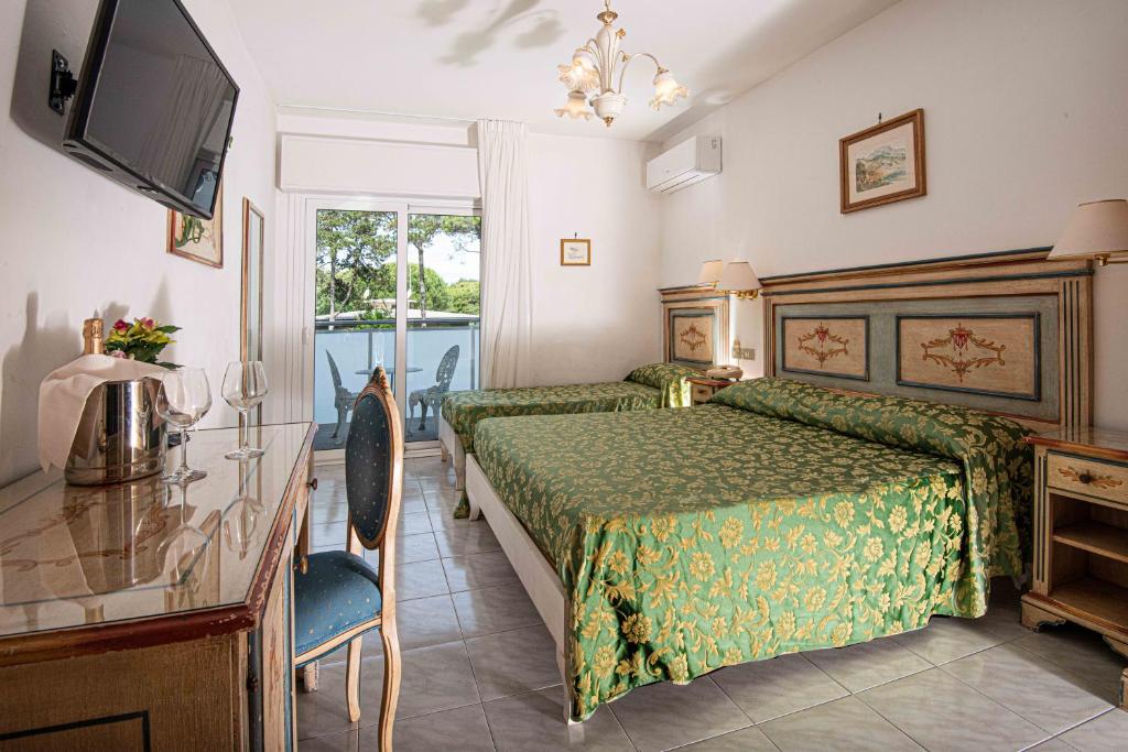 - une chambre avec un lit doté d'un couvre-lit vert dans l'établissement Hotel Oasi, à Lignano Sabbiadoro