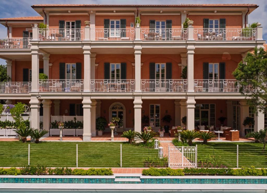 une grande demeure de caractère avec une piscine en face de celle-ci dans l'établissement Pensione America - Adults only, à Forte dei Marmi