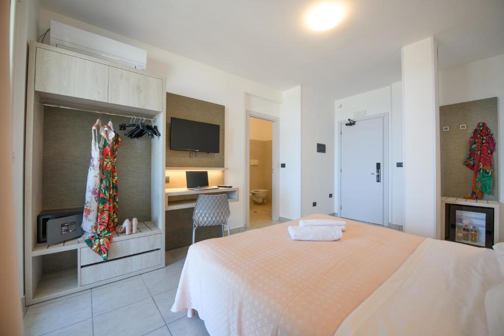 une chambre avec un lit et un bureau dans l'établissement Hotel Graziella, à Martinsicuro