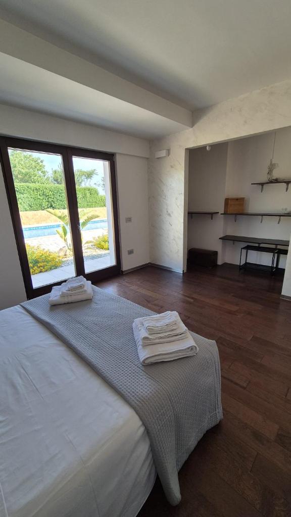 une chambre avec un grand lit avec des serviettes dessus dans l'établissement Li Canti di Giulia, à Casarano