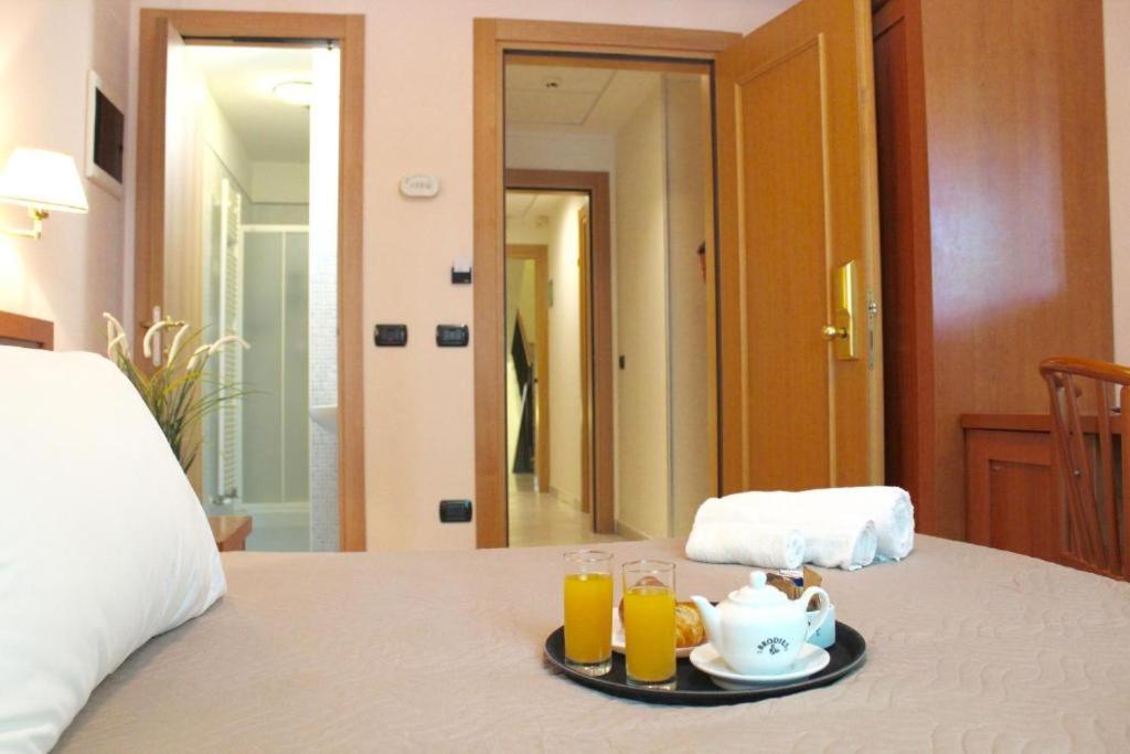un plateau avec un service à thé et deux verres de jus d'orange dans l'établissement Giole Hotel, à Cesenatico