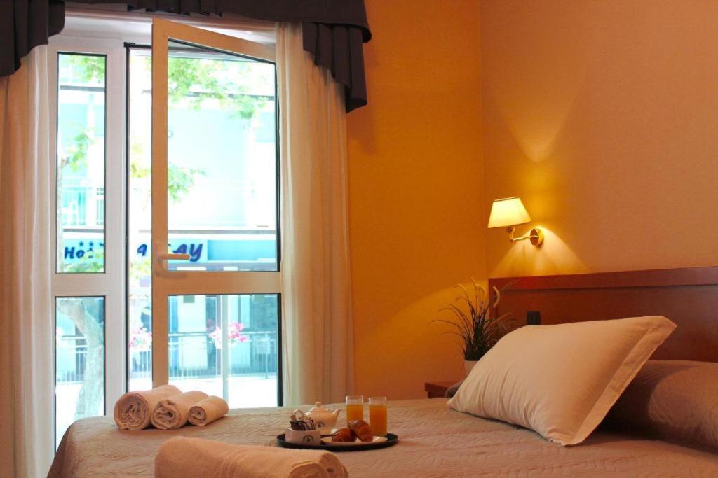 - une chambre avec un lit, des serviettes et une fenêtre dans l'établissement Giole Hotel, à Cesenatico