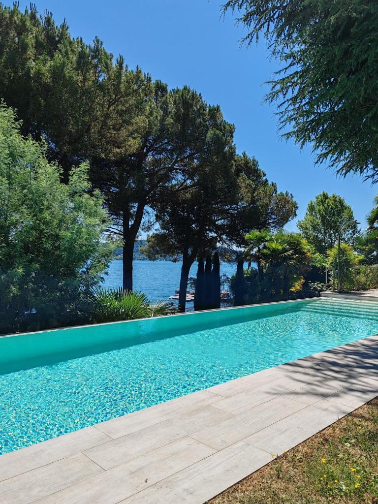 - une piscine avec des arbres et une vue sur l'eau dans l'établissement Casa Blanca, à Lesa