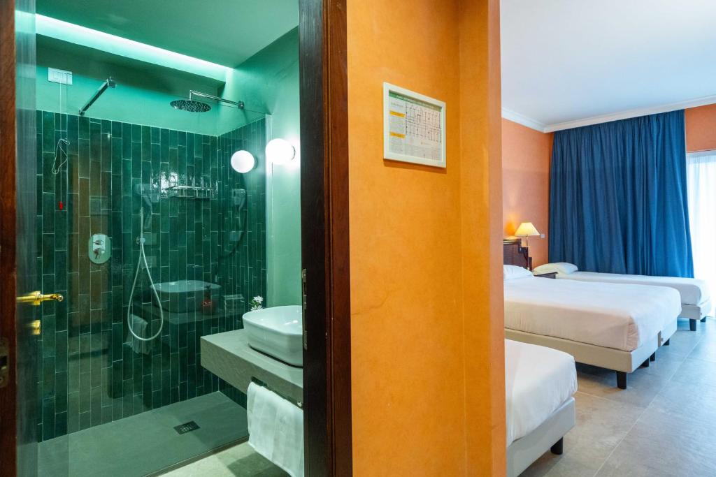 une chambre d'hôtel avec une salle de bain avec douche et lavabo dans l'établissement Hotel Schuhmann, à Paestum