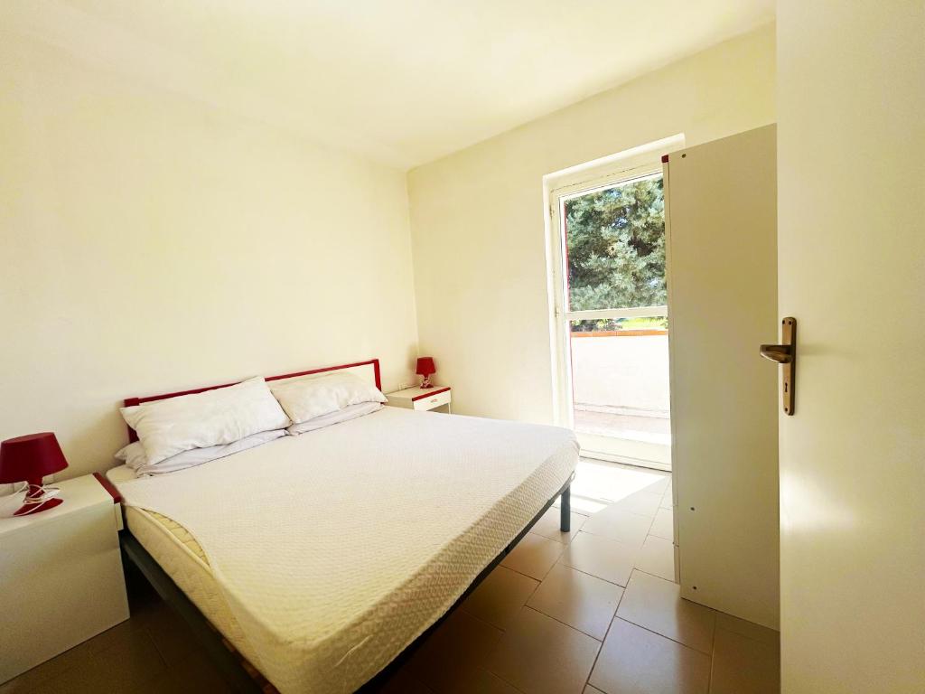 une chambre blanche avec un lit et une fenêtre dans l'établissement Case Vacanze a Rossano, à Rossano