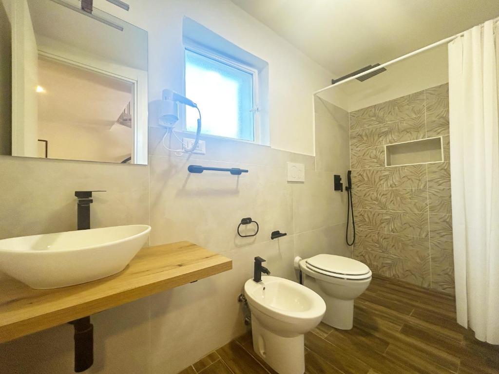une salle de bain avec un lavabo blanc et des toilettes dans l'établissement Case Vacanze a Rossano, à Rossano 73 autres photos