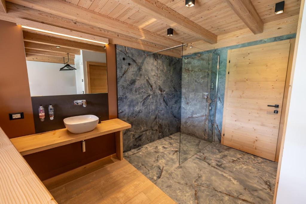 une salle de bain avec un lavabo et une douche dans l'établissement Bazzario Loft, à Lavarone