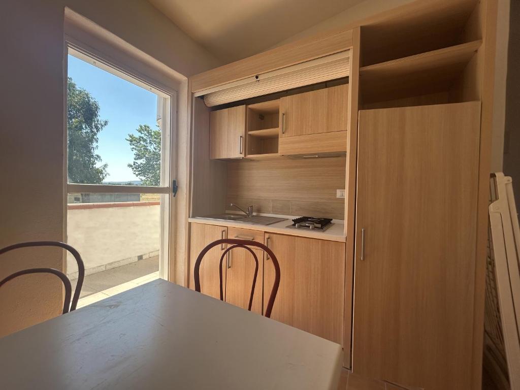une cuisine avec une table et des chaises et une fenêtre dans l'établissement Case Vacanze a Rossano, à Rossano
