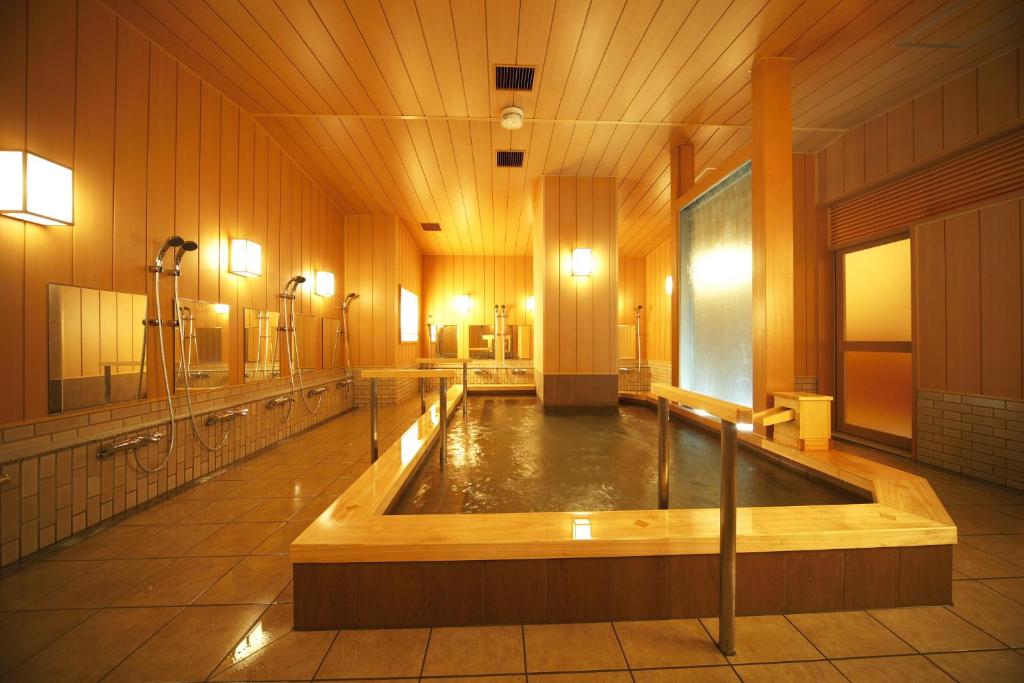 - une grande salle de bains avec baignoire au milieu dans l'établissement Matsui-Bekkan Hanakanzashi, à Kyoto