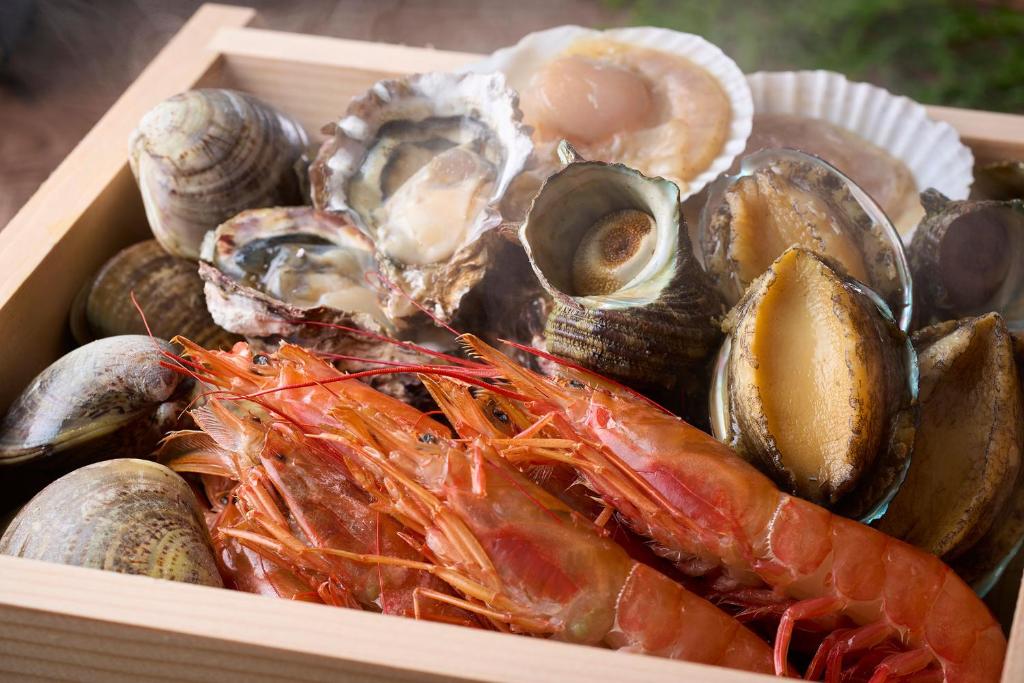 une boîte en bois remplie de différents types de fruits de mer dans l'établissement Ooedo Onsen Monogatari Awazu Grand Hotel, à Komatsu