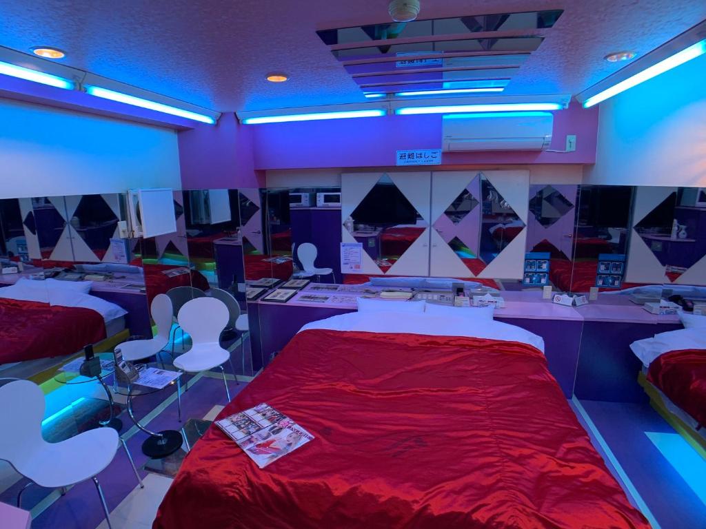 Cette chambre comprend 2 lits et un couvre-lit rouge. dans l'établissement 愛愛賓館 Adult Only, à Wada