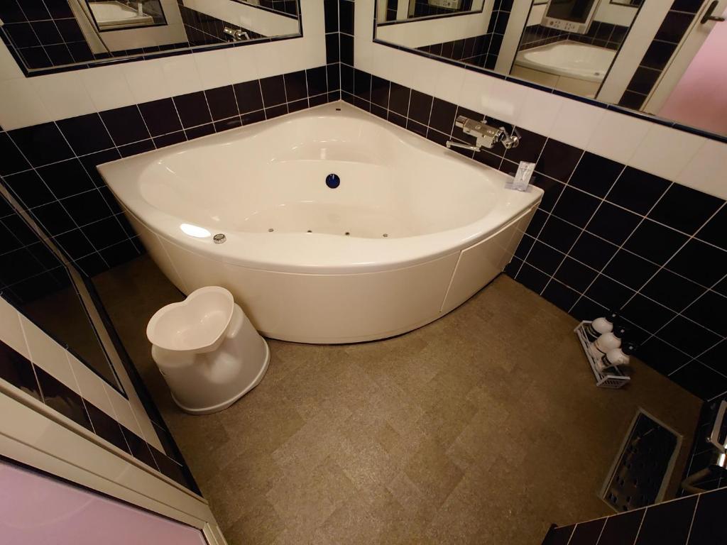 La salle de bains est pourvue d'une baignoire blanche et d'une poubelle. dans l'établissement 愛愛賓館 Adult Only, à Wada